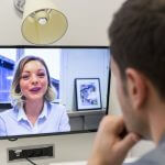 A man having a teleconference with a young blonde woman.