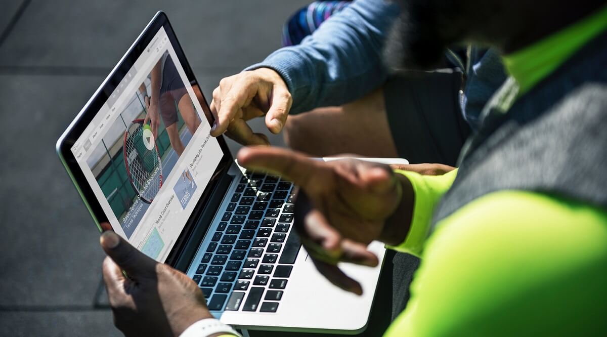 Two men looking a video on a MacBook Pro.