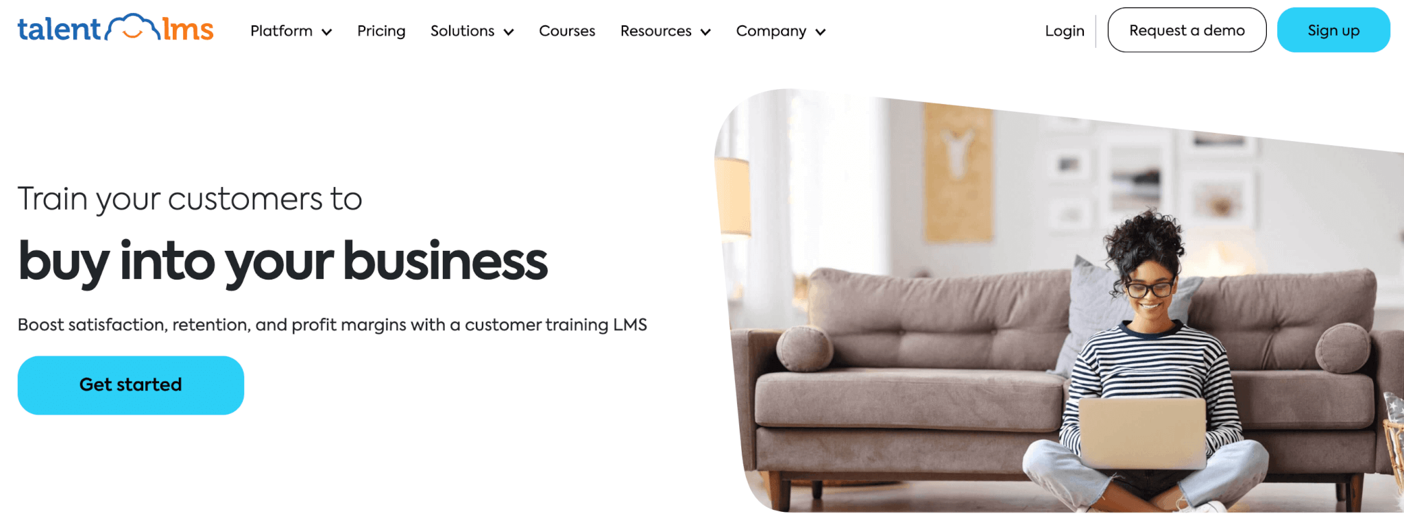 a screenshot of TalentLMS landing page showing a young woman sitting by the sofa with a top in her lap